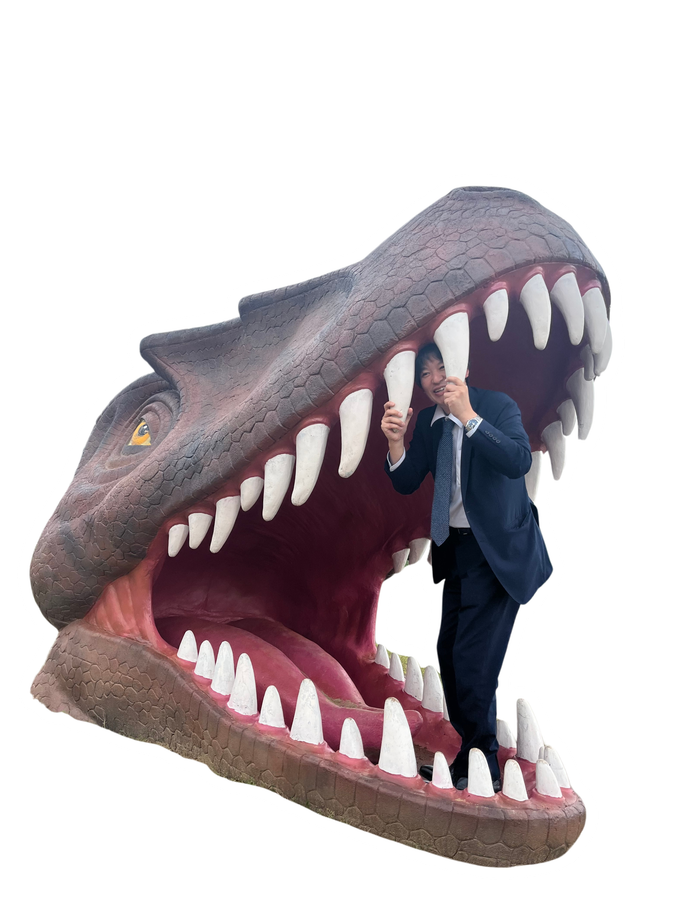 恐竜の口の中に立つ社員